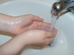 Close-up of handwashing at a sink.